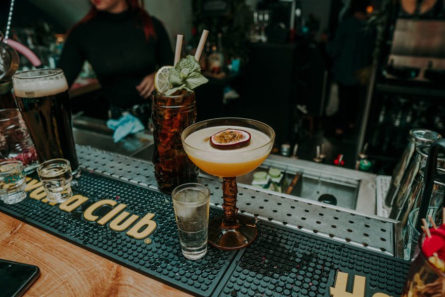 Cocktails and beer lined up on a bar counter