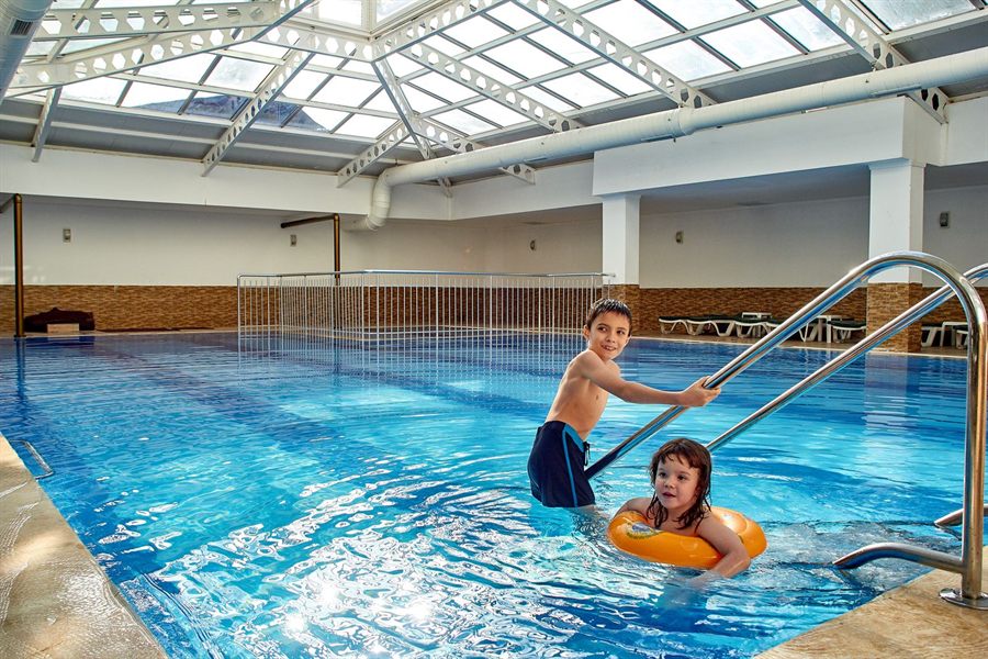 Two children playing in an indoor swimming pool