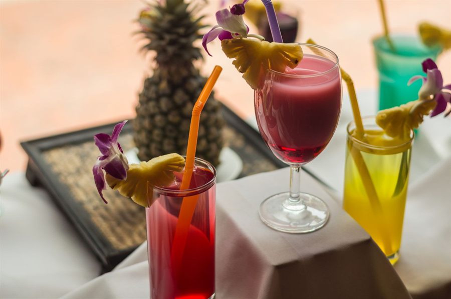 Colorful tropical cocktails garnished with pineapple and flowers